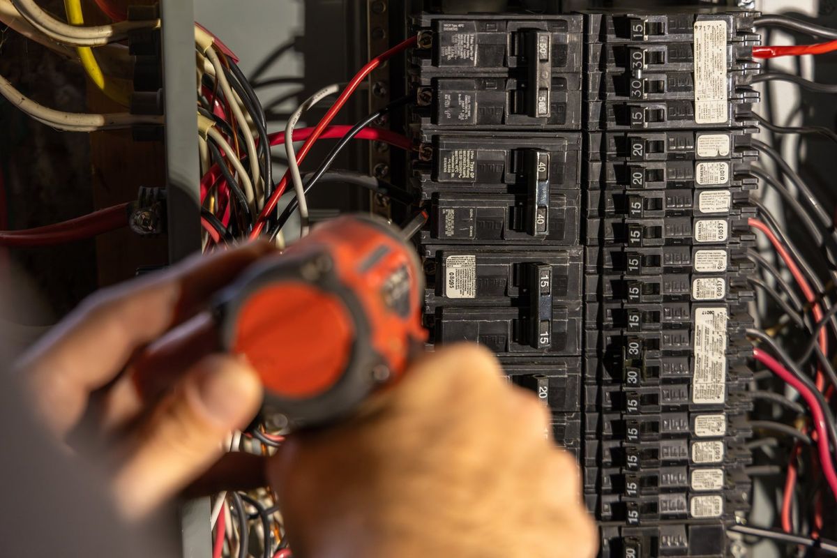 Electrician testing circuit breakers in a residential electrical panel